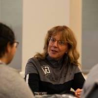 A staff member chats with a student at a round table